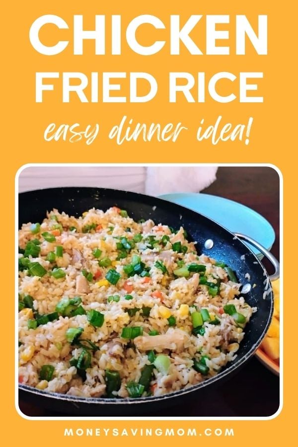 Large skillet filled with colorful chicken fried rice, garnished with chopped green onions, sitting on a table next to a light blue plate. Bold text above the image reads “Chicken Fried Rice – Easy Dinner Idea!” on an orange background.